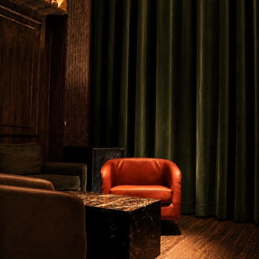 Private velvet-curtained corner with leather armchair and marble table