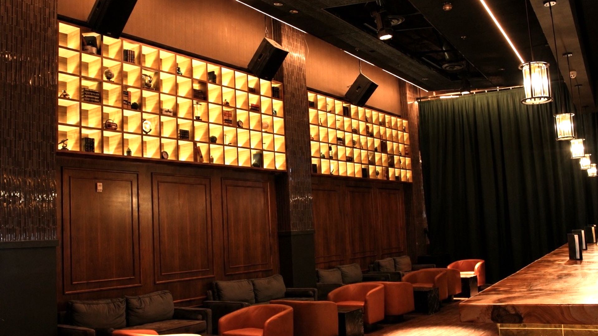 Lounge seating beneath the illuminated card-catalog wall at Archive Sacramento